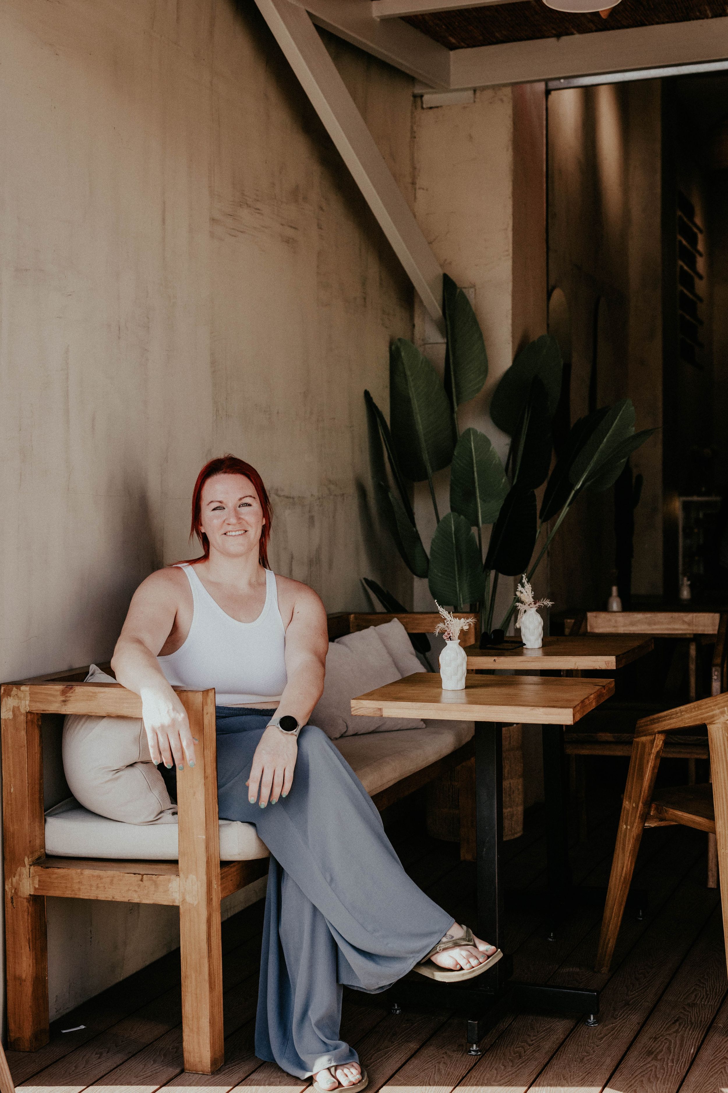 Lifestyle photoshoot in a rustic setting with wooden furniture and indoor plants against concrete walls.