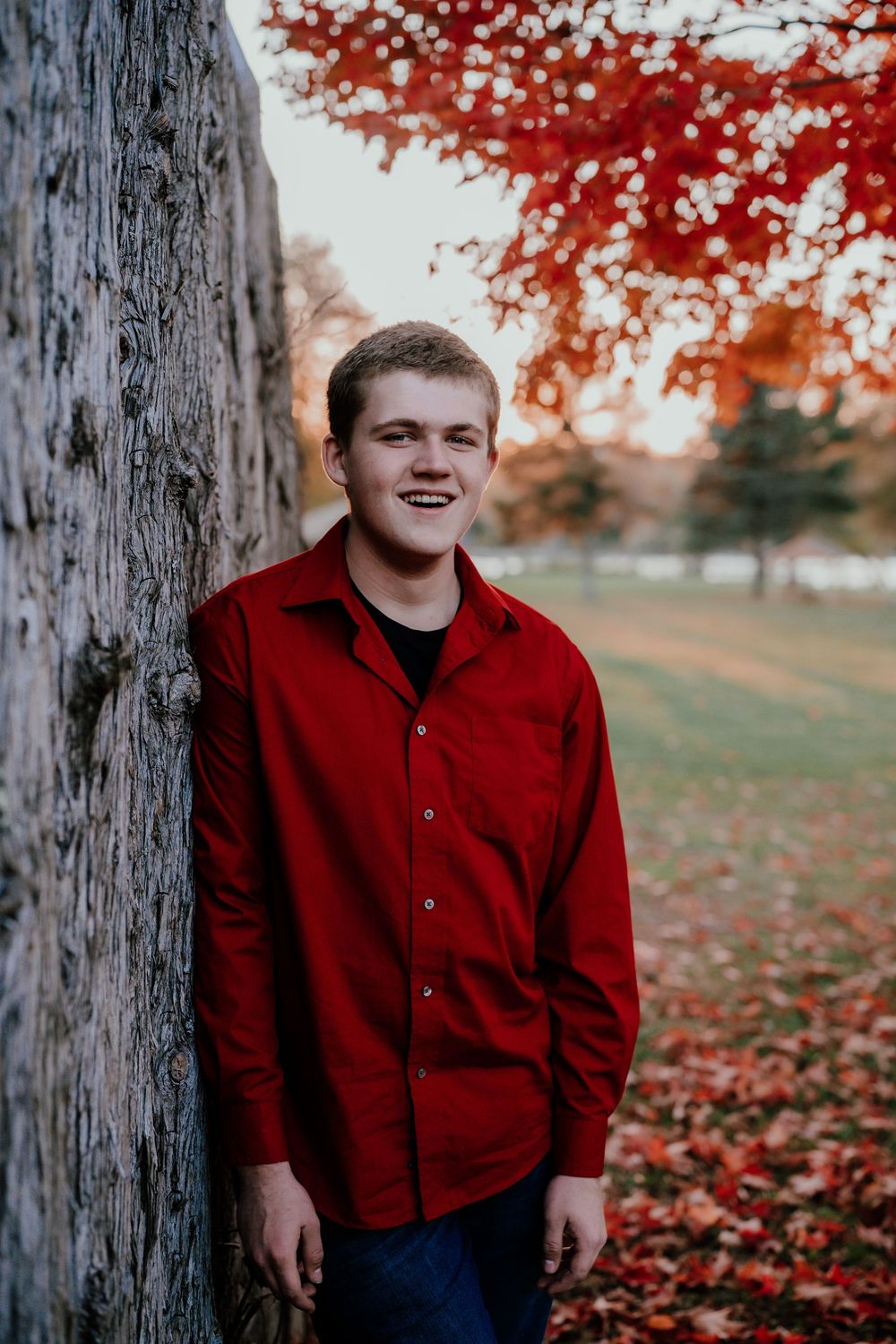 Four outdoor portrait photos in autumn showing someone in a red shirt against a tree with red fall foliage in the background.