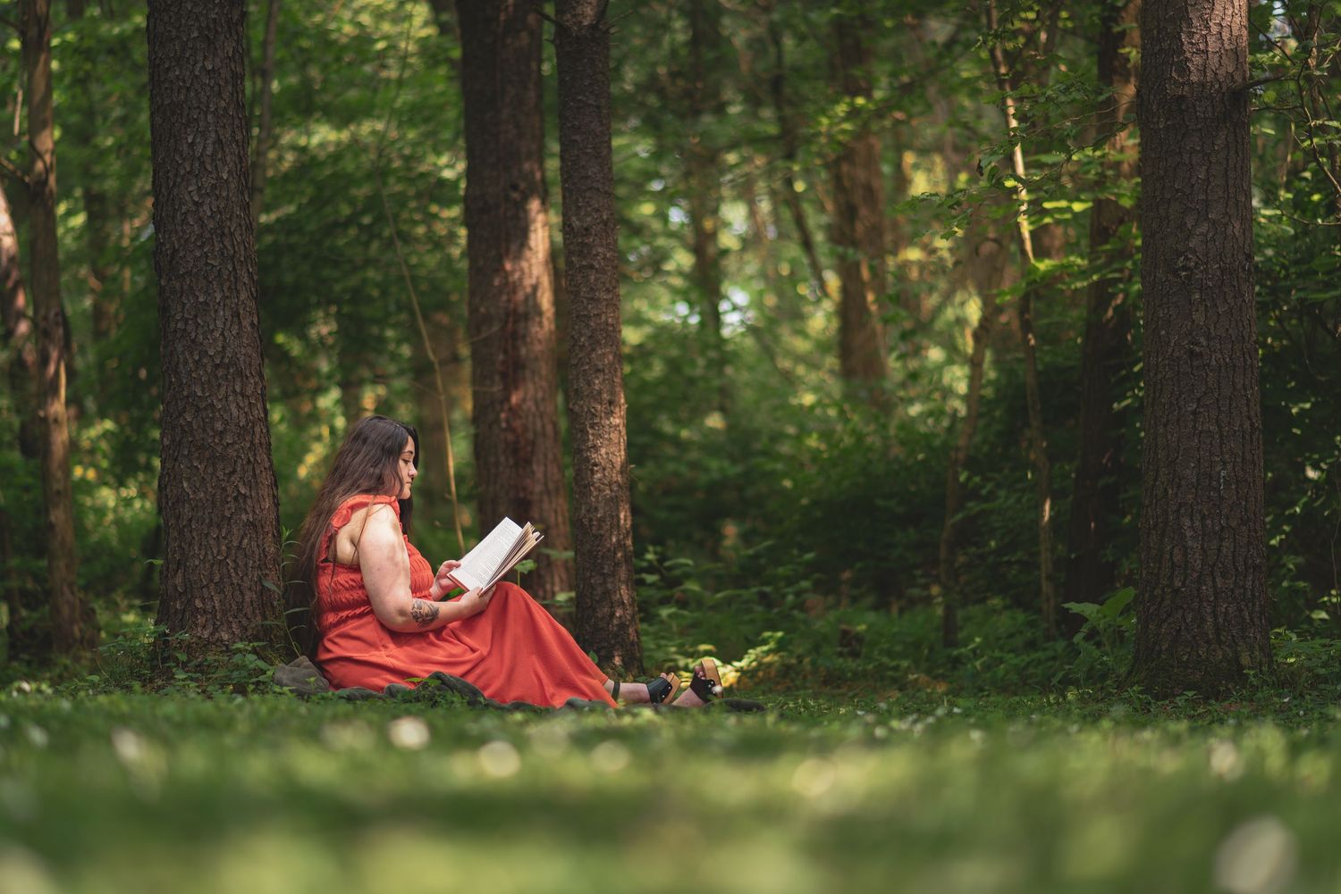 Romantic forest photography session with red dress and natural lighting.