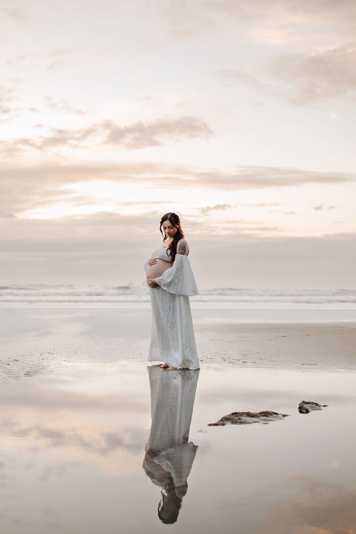 Maternity portrait of expectant mother during golden-hour at beach Westport NZ
