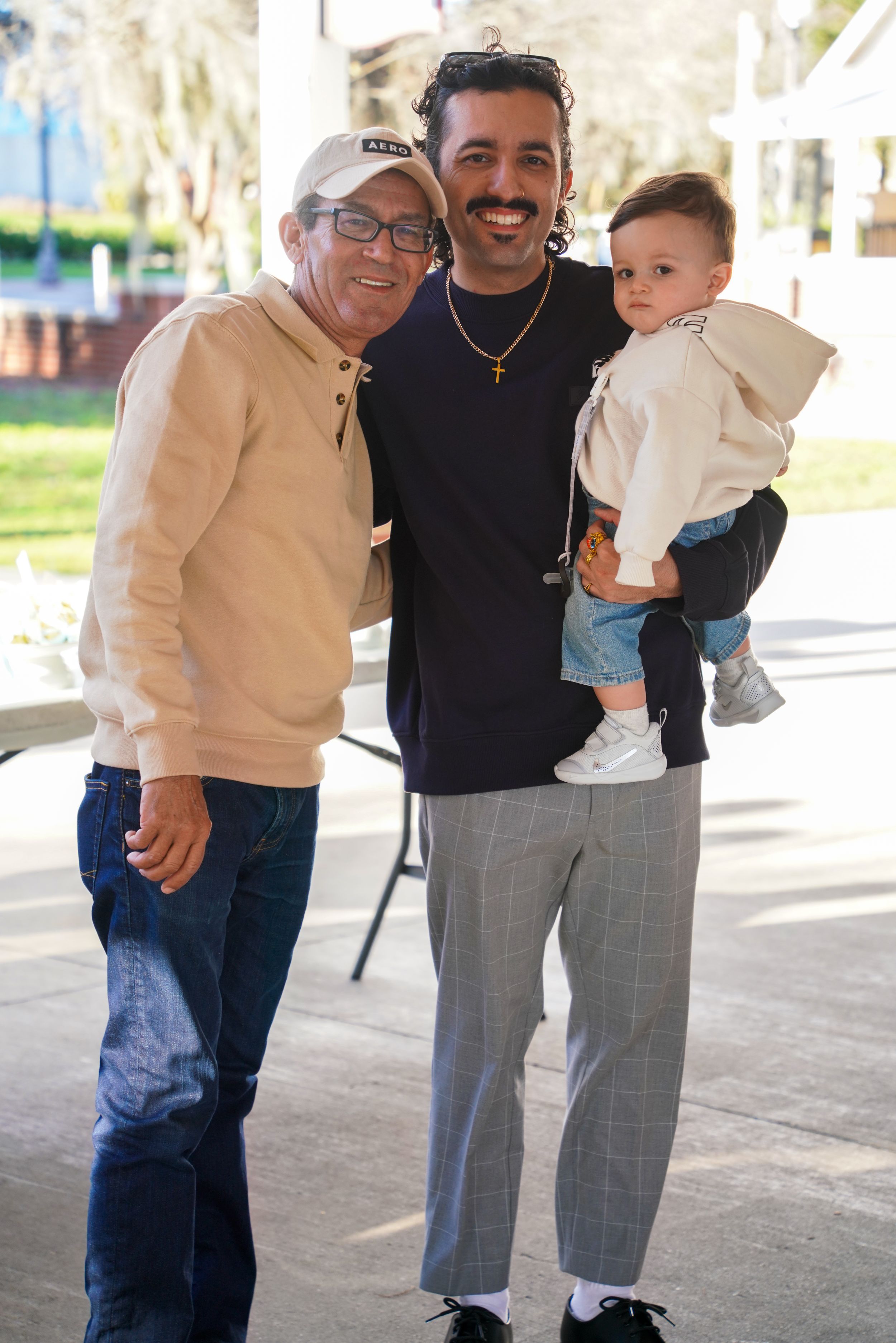 Family gathering outdoors with casual attire and joyful expressions.