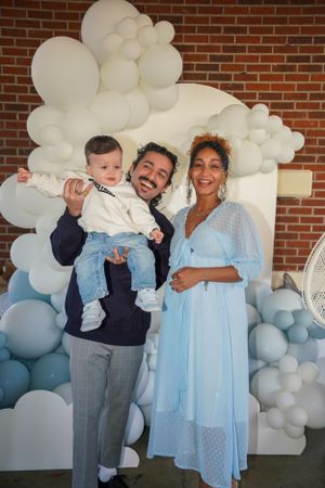 Festive gathering with light blue dresses and balloon decorations at a celebration event.