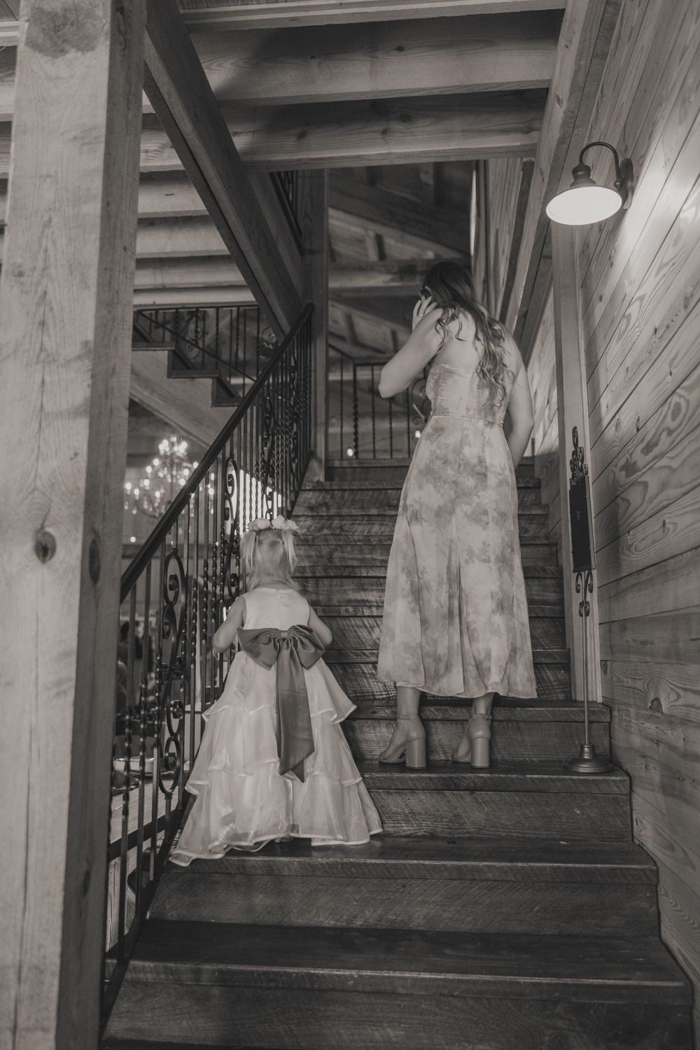 Elegant wedding dresses hanging on display along a wooden staircase in vintage style.