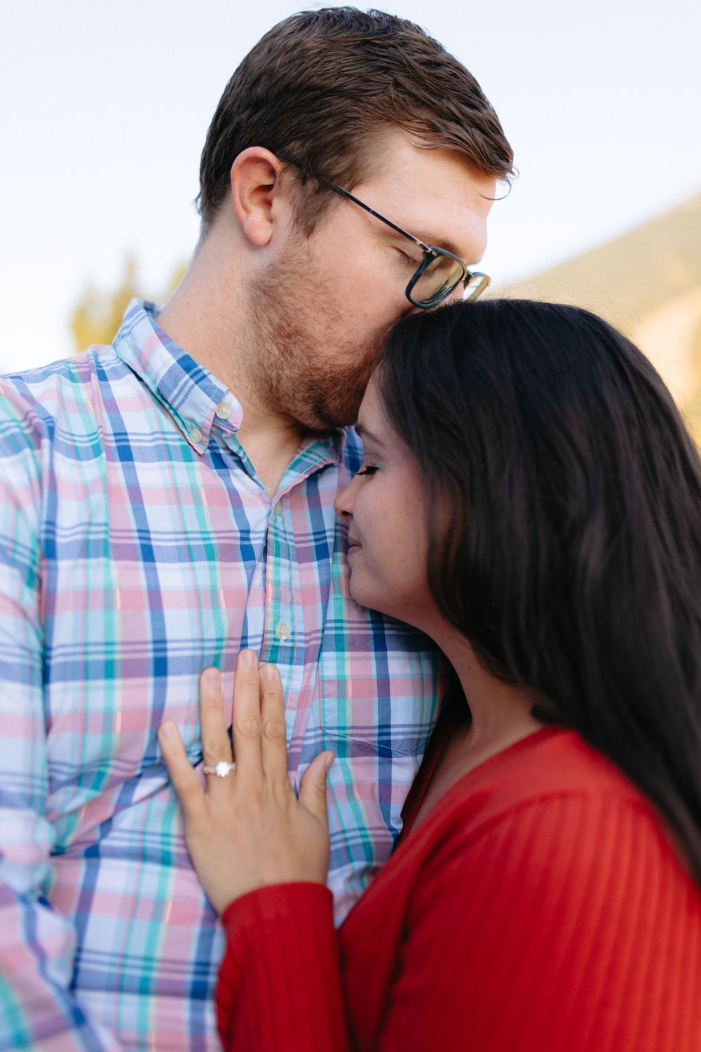A romantic couple in plaid shirt and red sweater share intimate moments in a series of connected photos.