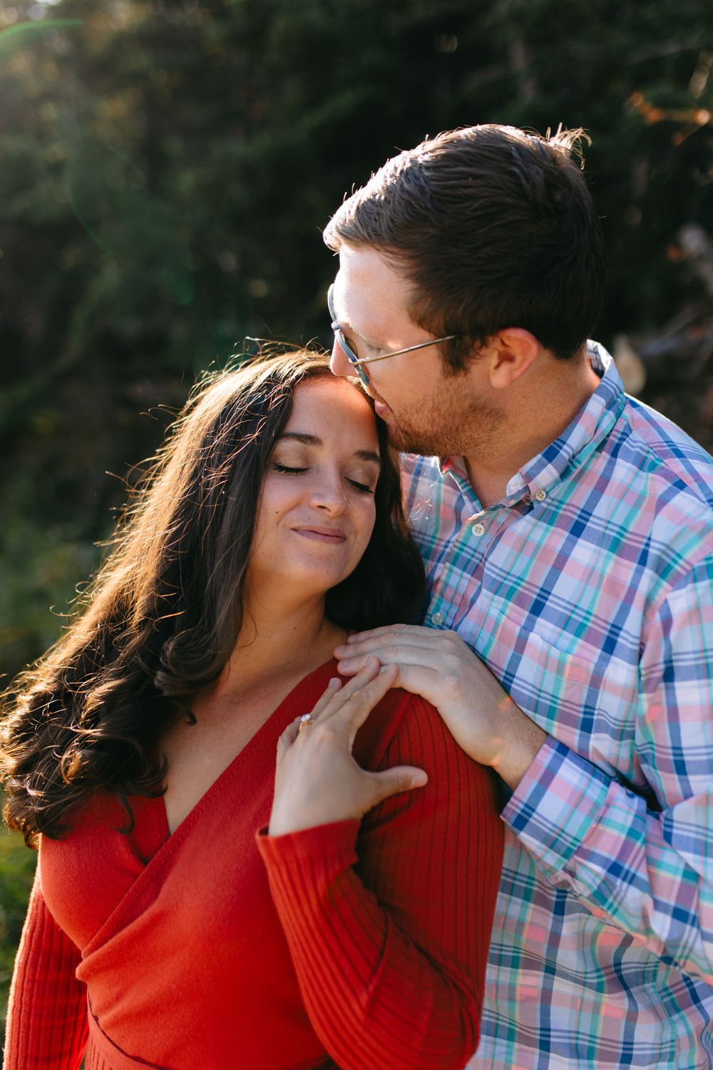 Intimate couple portraits in red sweater and plaid shirt during sunset photo session.