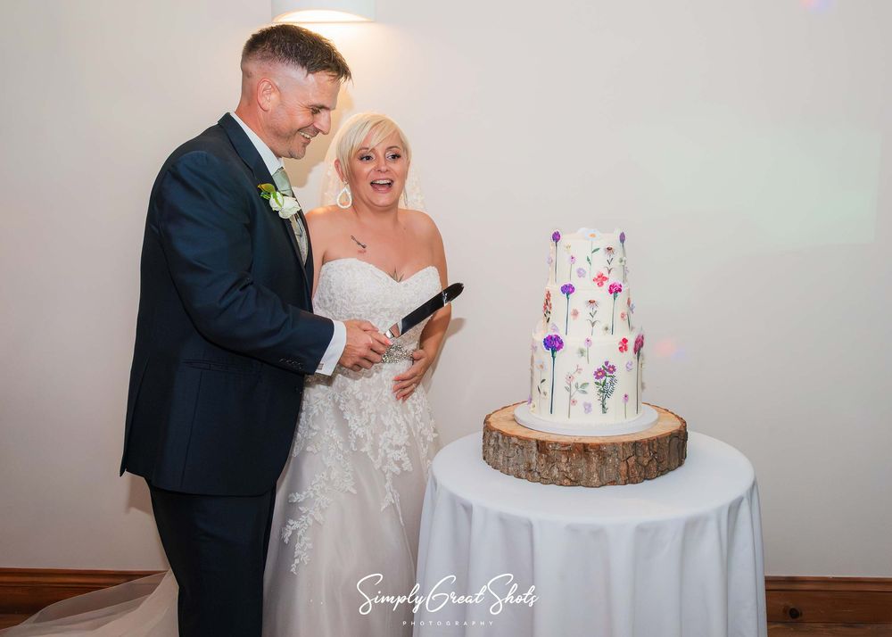 Winters Tale Country Barn Wedding Photographer captures the moments before the bride and groom cut the wedding cake.