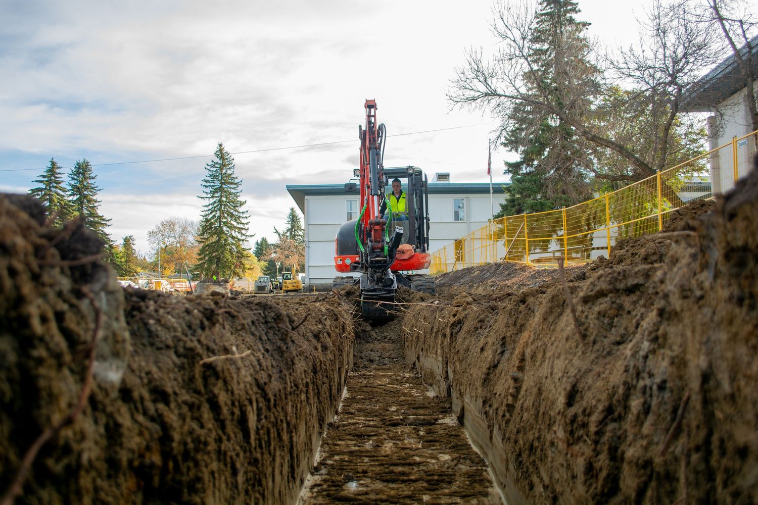 excavation trench low angle photography taken from inside the pit but prioritizing safety wearing ppe in sherwood park alberta edmonton