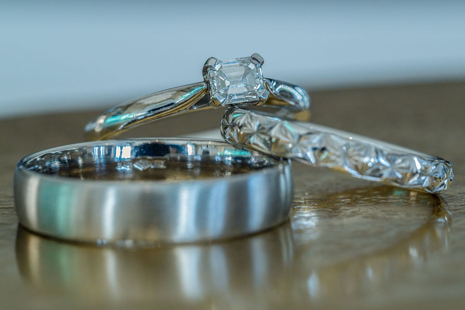 A close-up macro photograph shows a sparkling diamond engagement ring with intricate details and reflections.