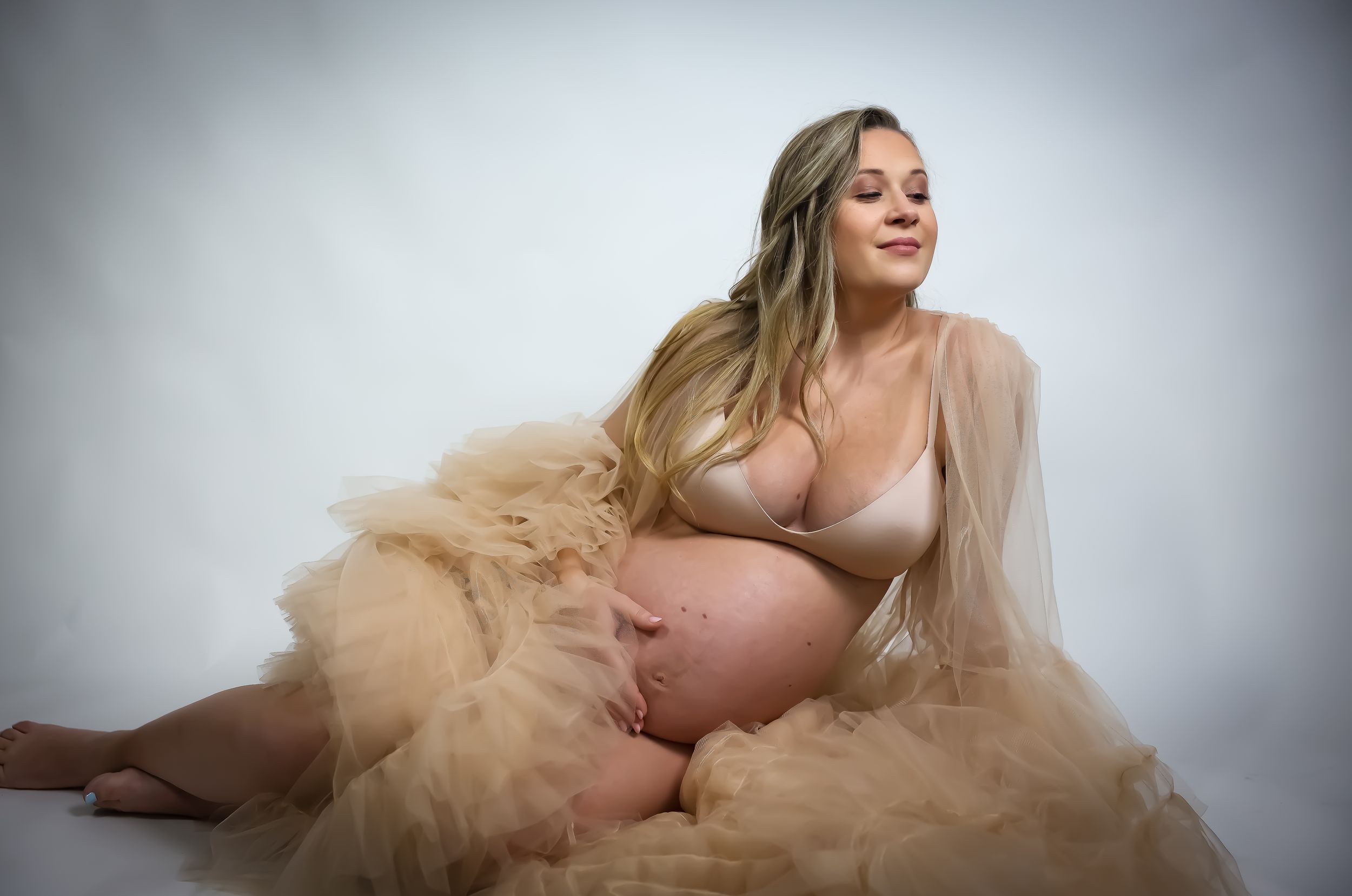 Elegant maternity portraits featuring a champagne-colored tulle gown.