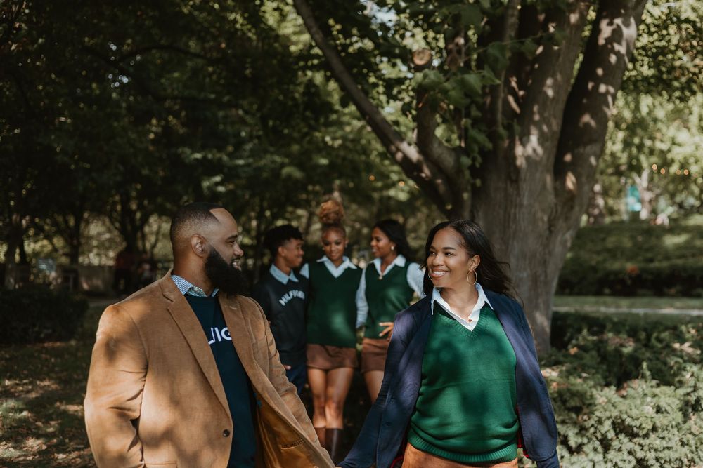 A group gathers outdoors for a photo in a garden setting wearing casual attire and green clothing.