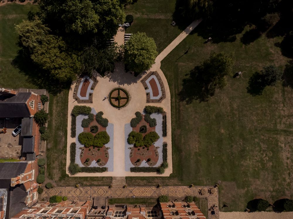 Bird's eye view of symmetrical formal gardens with geometric patterns and pathways.