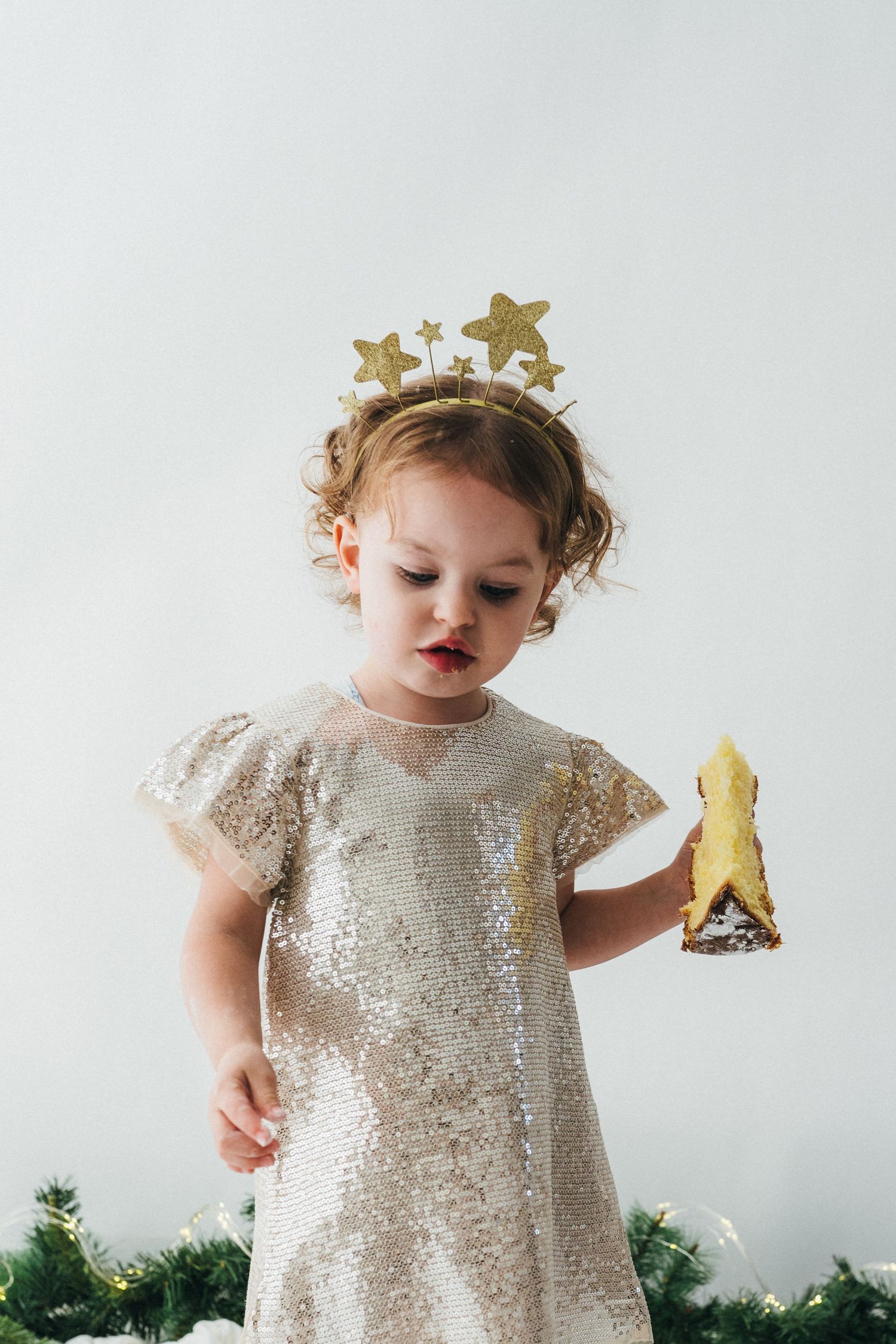 Petite fille en robe pailletée tenant un morceau de Pandoro pendant une mini-séance photo d’hiver au studio Mon Amour des Photos à Fameck