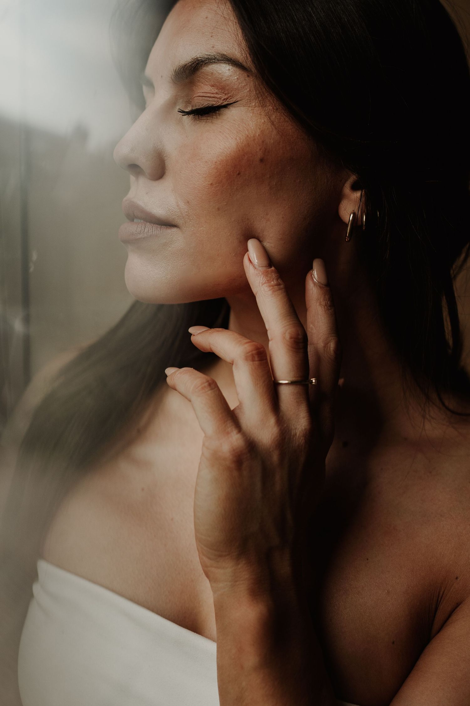 Intimate artistic portrait series showing closeup details of neck, jawline and profile in warm moody lighting.