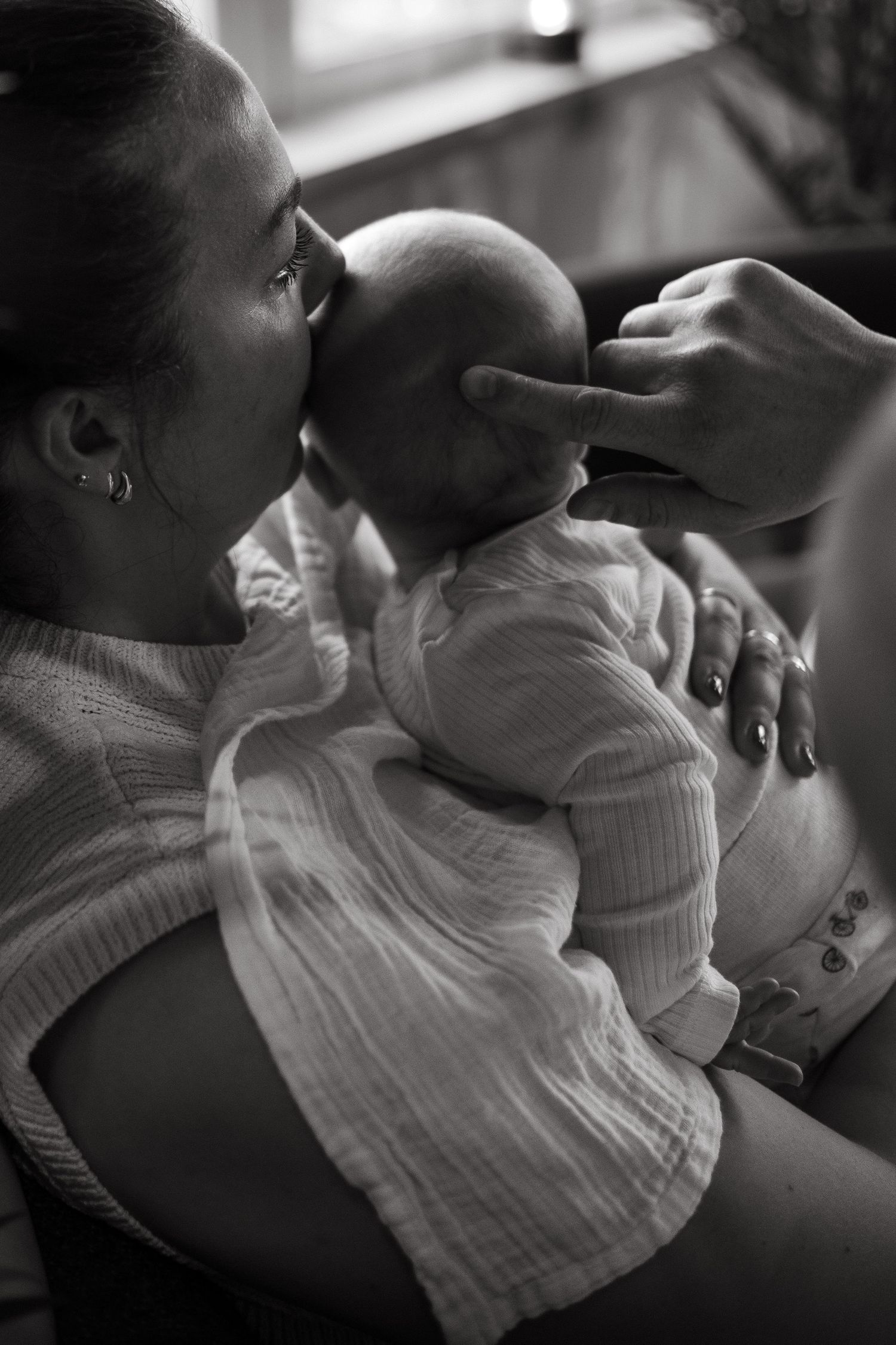 woman kissing the head of her newborn while being captured by English-speaking photographer for tourists in Stockholm