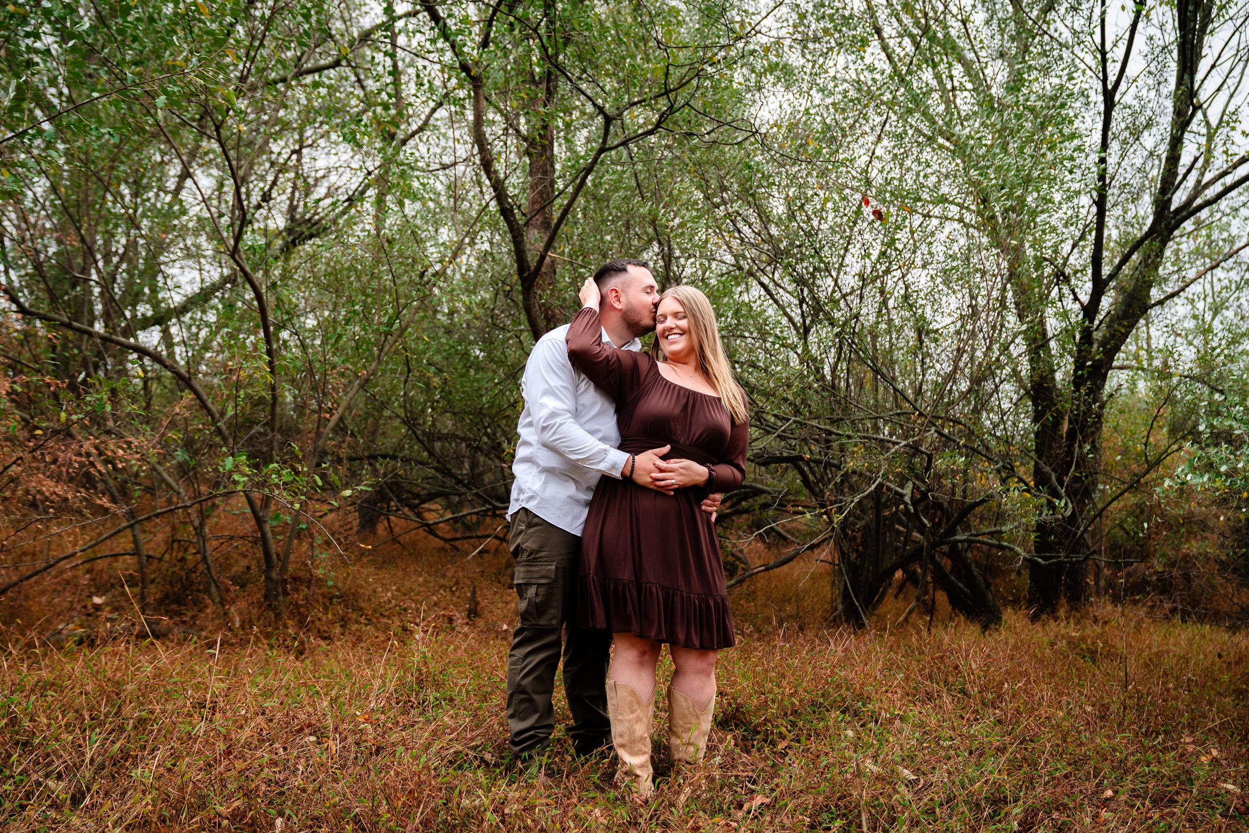 Couple walking through a serene wooded path during their engagement session.