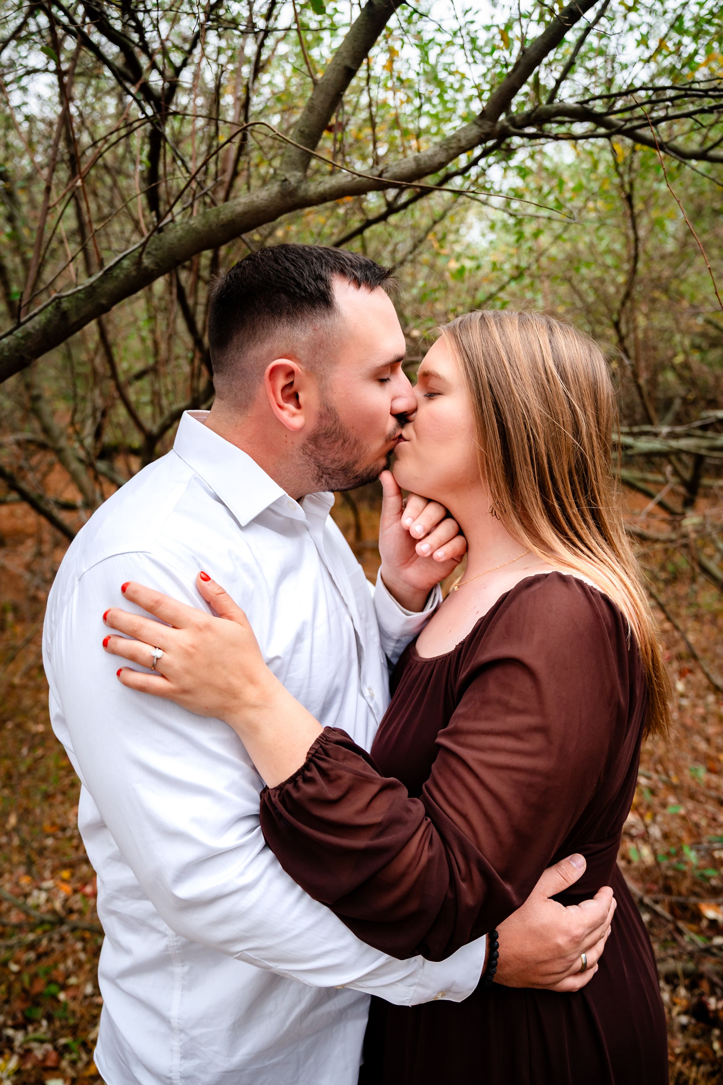 Intimate moment captured between couple during autumn engagement photoshoot.