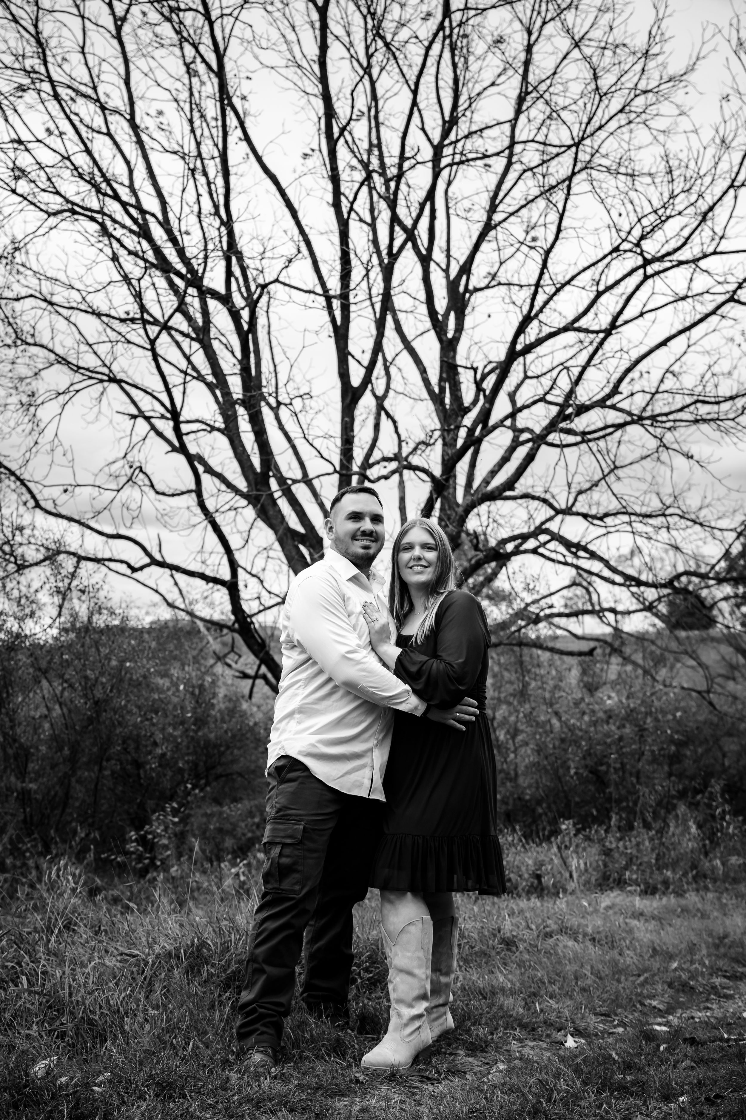 Black and white engagement photos with bare winter trees in background.