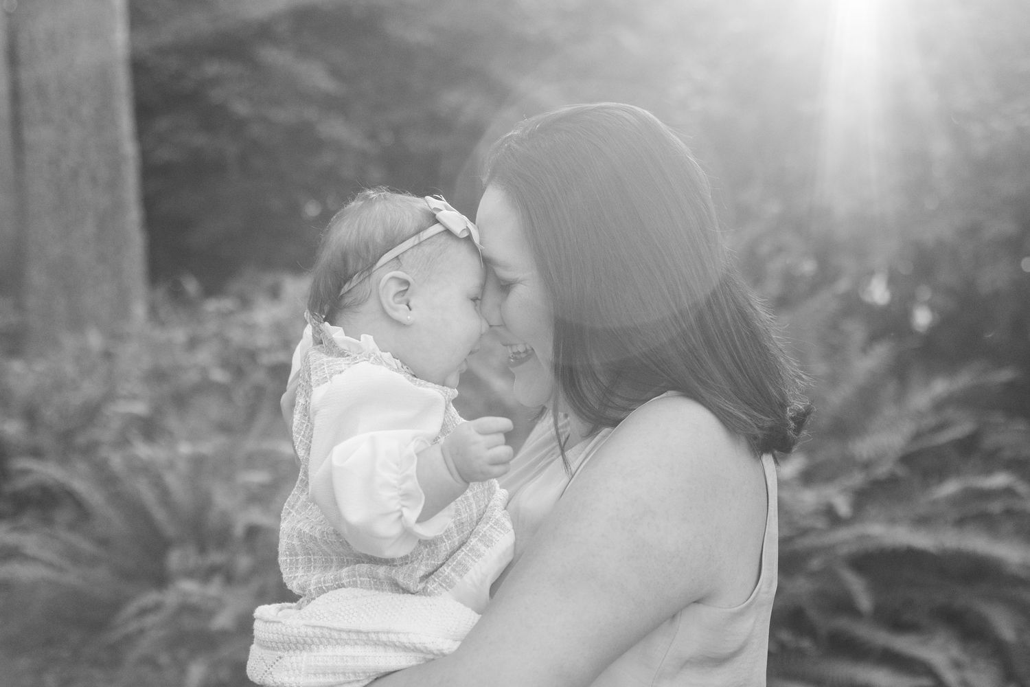 Intimate black and white portrait of a tender family moment outdoors.