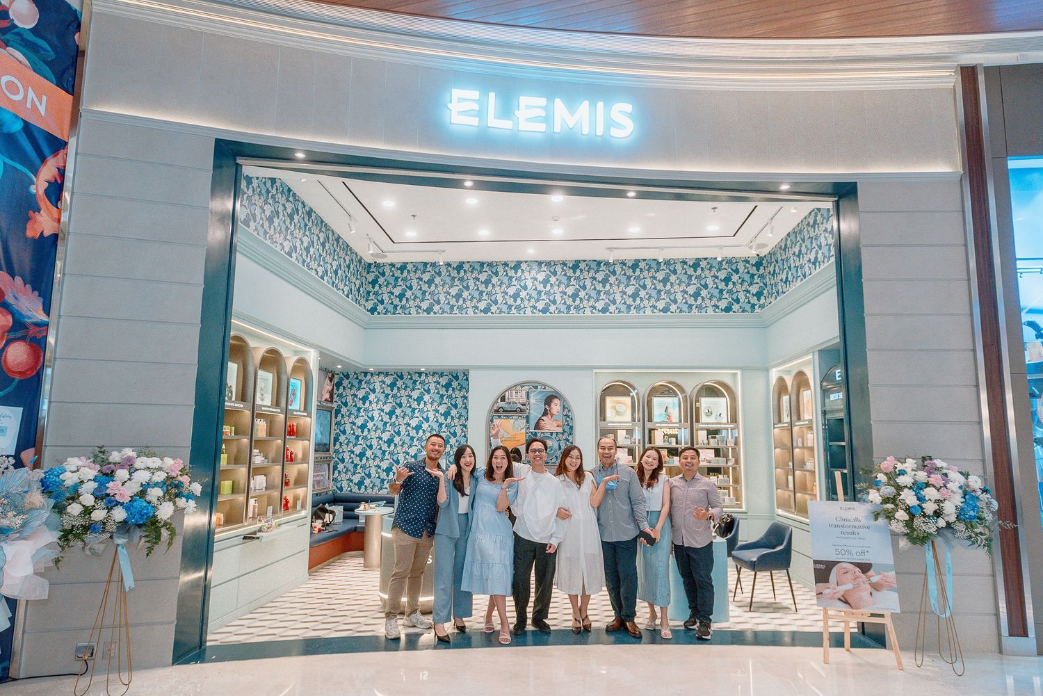 Interior view of an Elemis spa retail store with blue and white decor, product displays, and modern lighting fixtures.