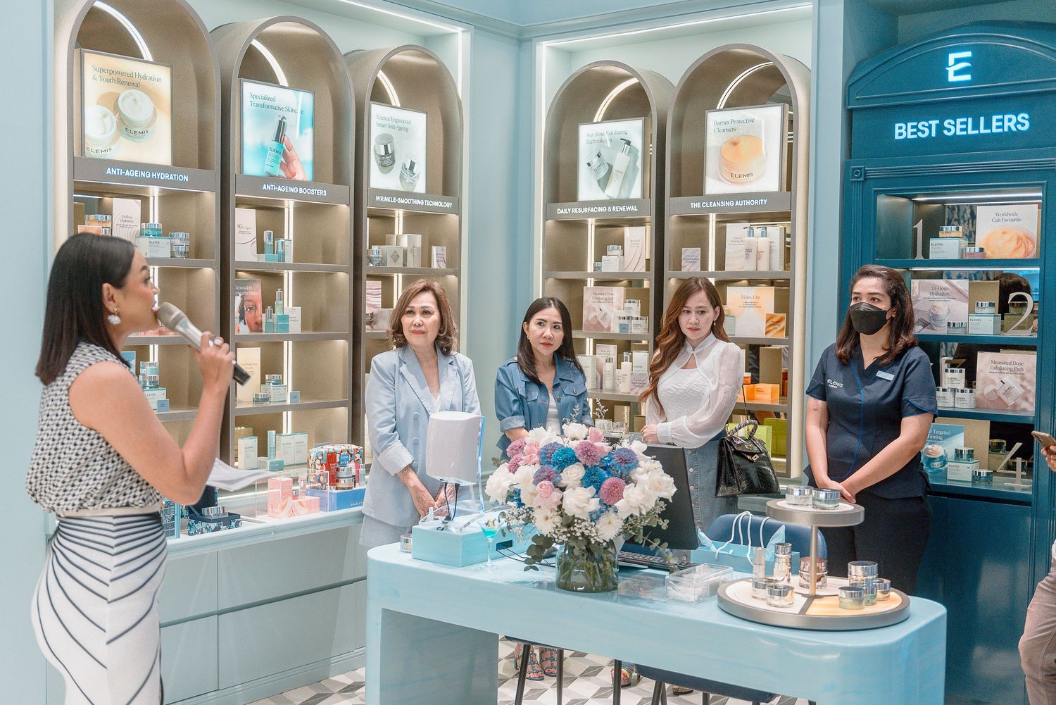 Customers browse and shop inside a modern jewelry store with glass display cases and bright lighting.