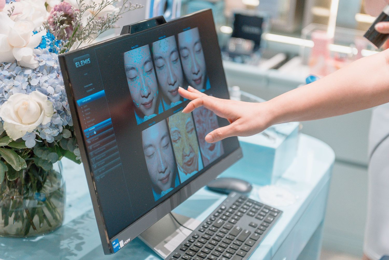 A laptop displays a digital presentation while hands interact with the screen during a business meeting.