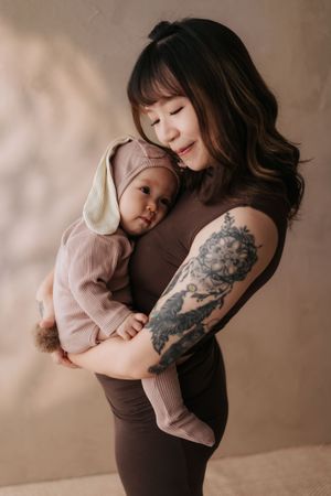 A tender moment captured in a series of photos showing a parent in brown shirt embracing a child in pink sweater.一組照片捕捉了一個溫馨的瞬間：一位身穿棕色襯衫的家長