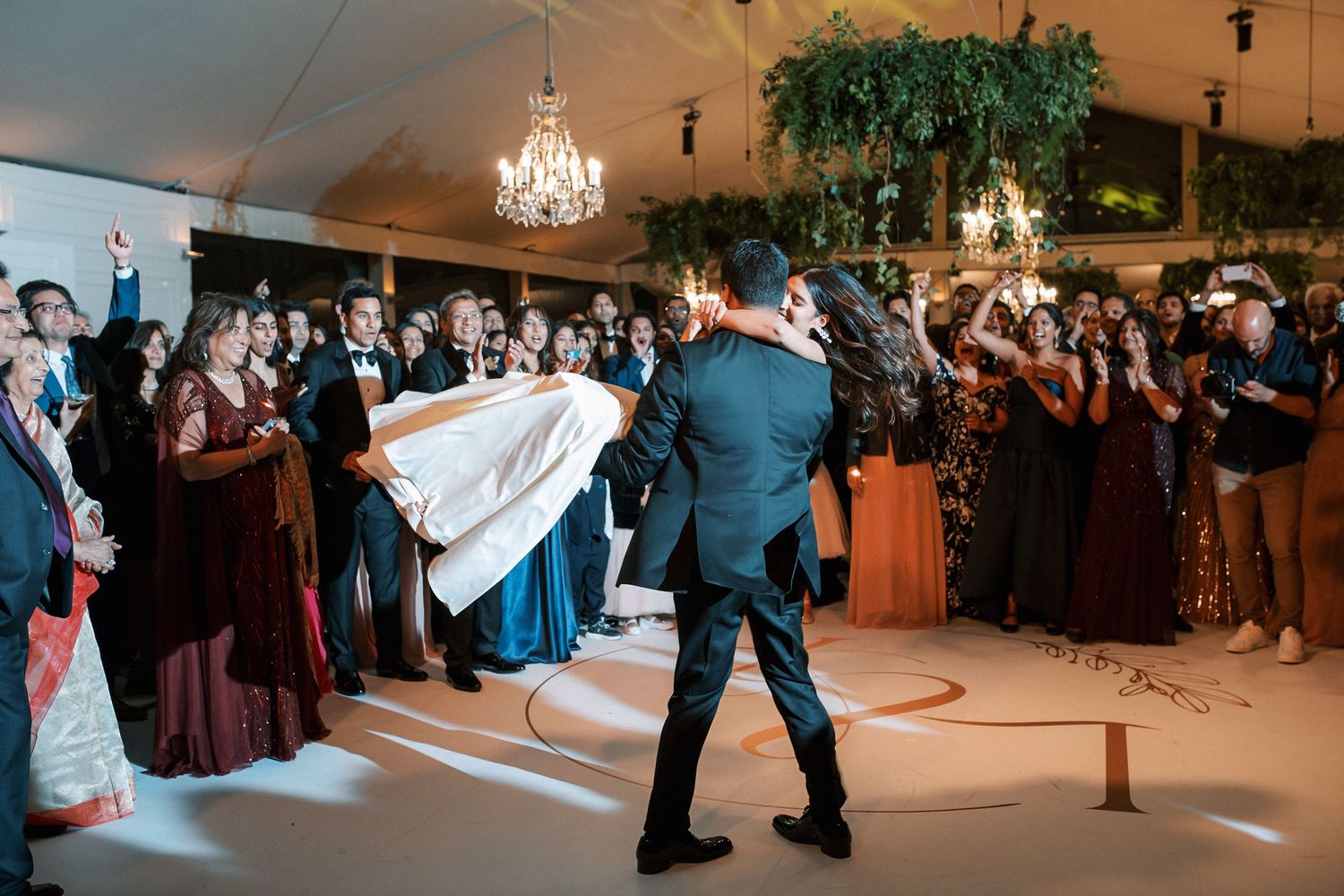 Bride and groom first dance surrounded by guests at luxury Indian wedding reception in Portugal at Corrio-Mor palace
