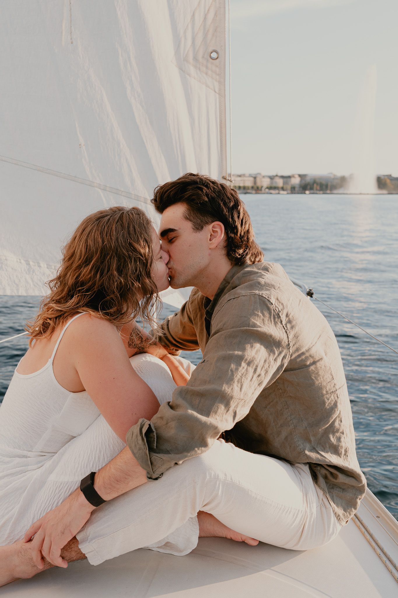 A romantic couple shares intimate moments on a boat during sunset, captured in a series of progressive kissing shots.