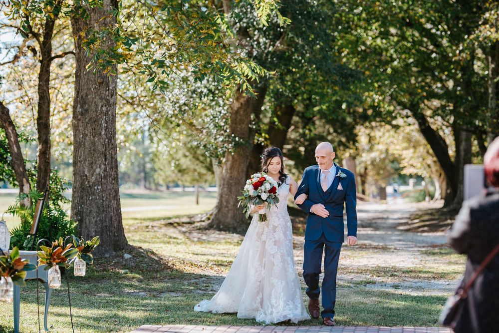 A sunny outdoor wedding ceremony among tall trees on a beautiful autumn day.