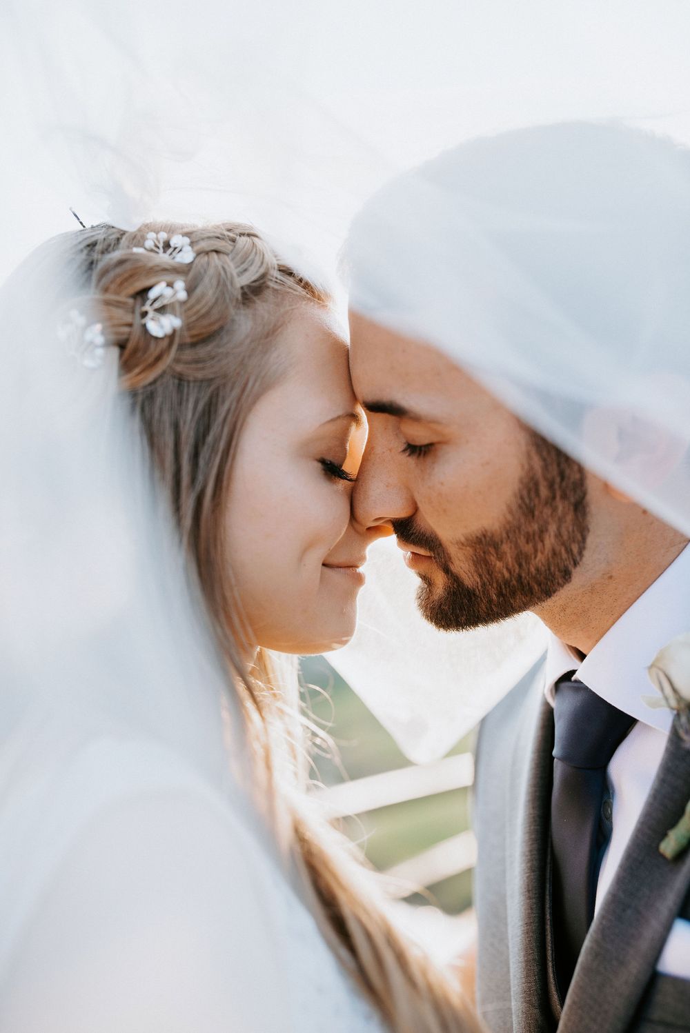 Close up romantic wedding photos of a couple in soft lighting sharing an intimate moment.