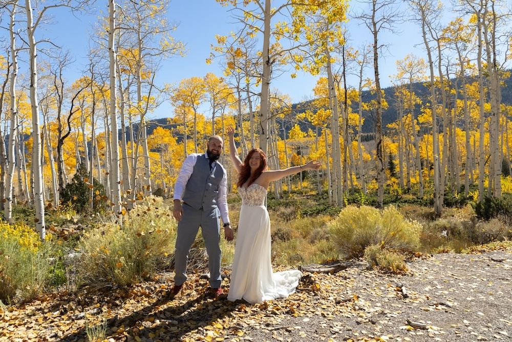 Couple embracing among golden aspen trees during an autumn mountain wedding photoshoot in Colorado.