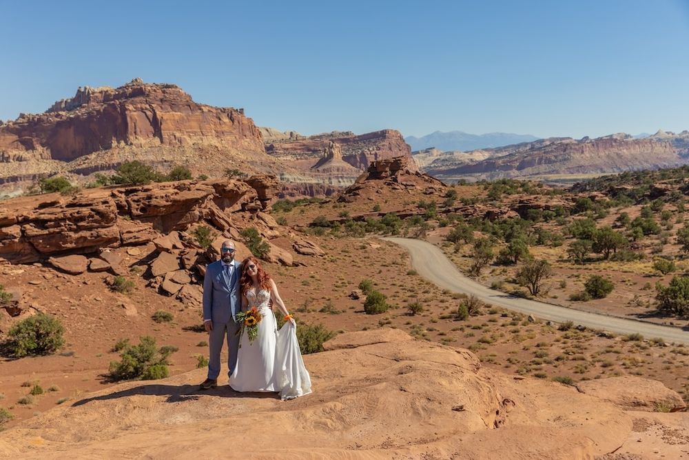 Scenic panorama of red rock formations and winding roads through Arches National Park in Utah during golden hour.