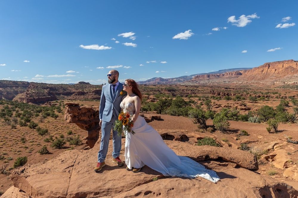Scenic panoramic view of red rock formations and desert landscape under blue skies at Arches National Park.