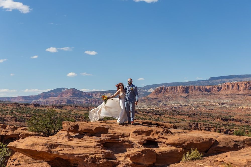 A panoramic view of red rock formations and desert landscape under blue skies at Dead Horse Point State Park in Utah.