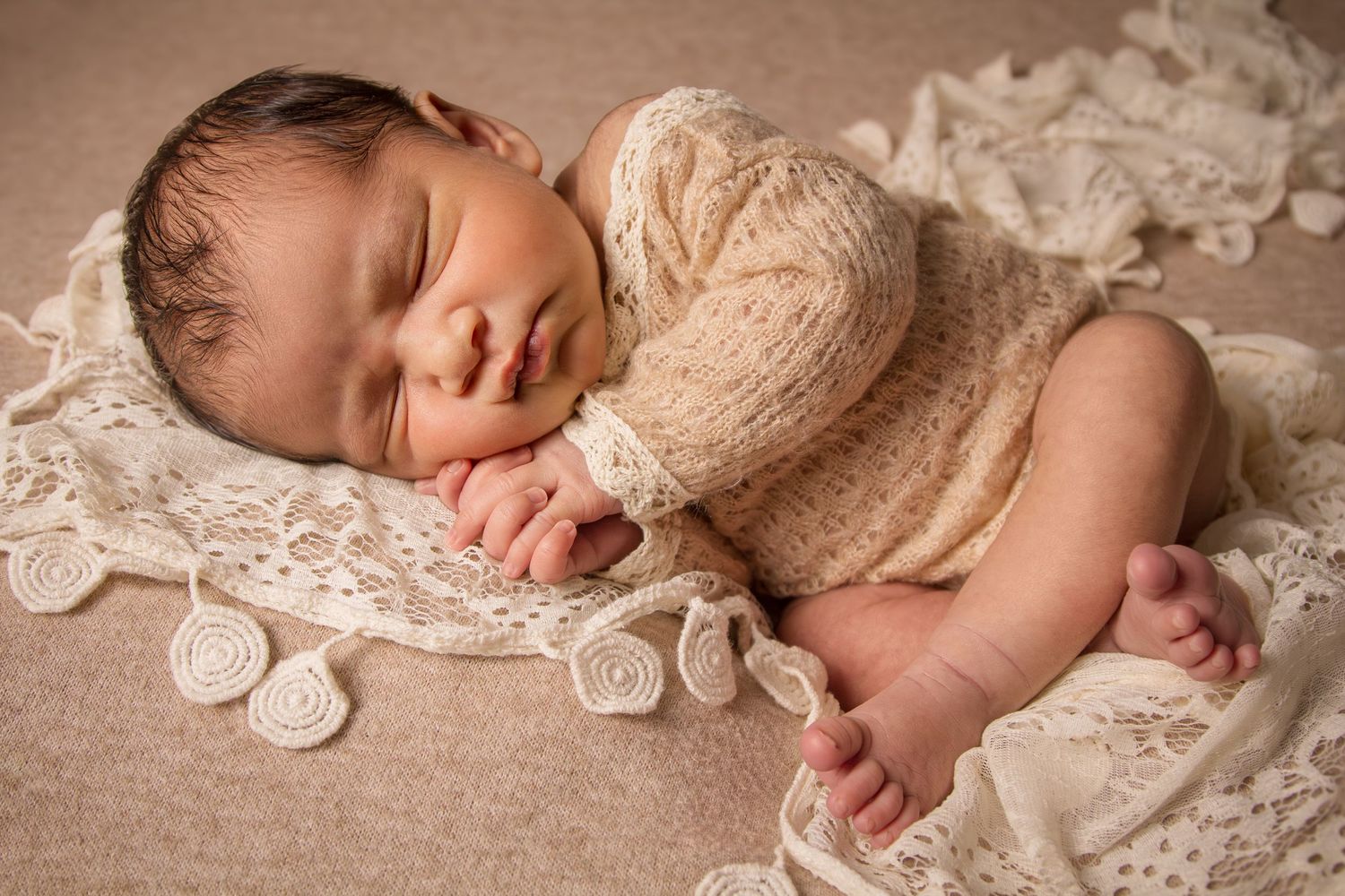 newborn session sleeping baby with clasped hands - neutral tones lacy fabric Mississauga Studio - baby photographer
