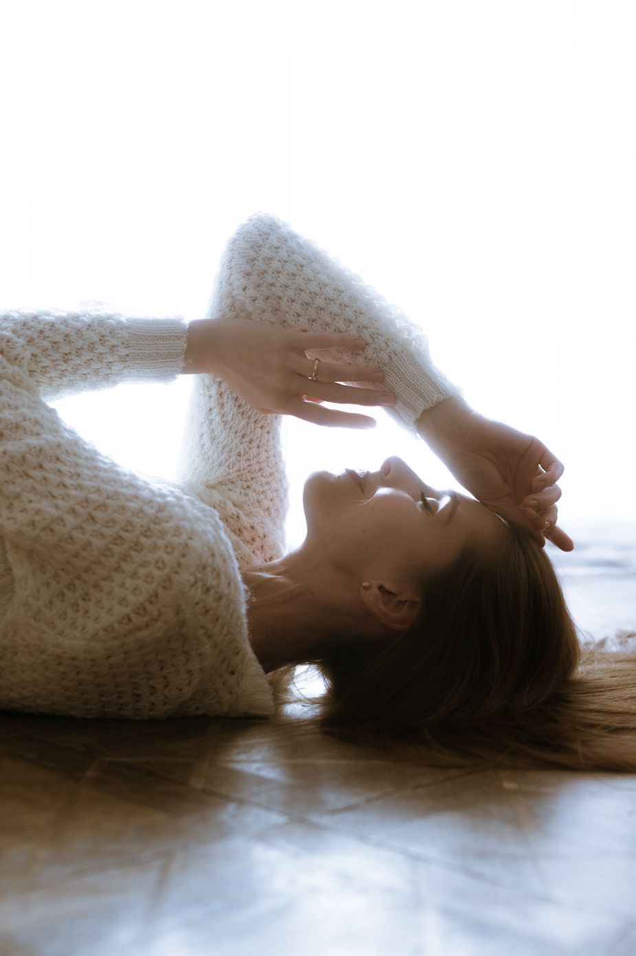 A soft and dreamy sequence of silhouettes lying down in white knitted fabric with gentle lighting.