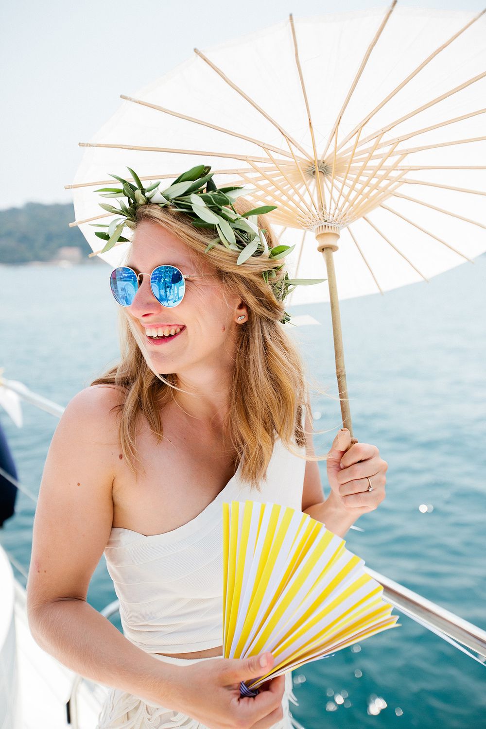 Bride with white parasol during a catamaran wedding on the French Riviera