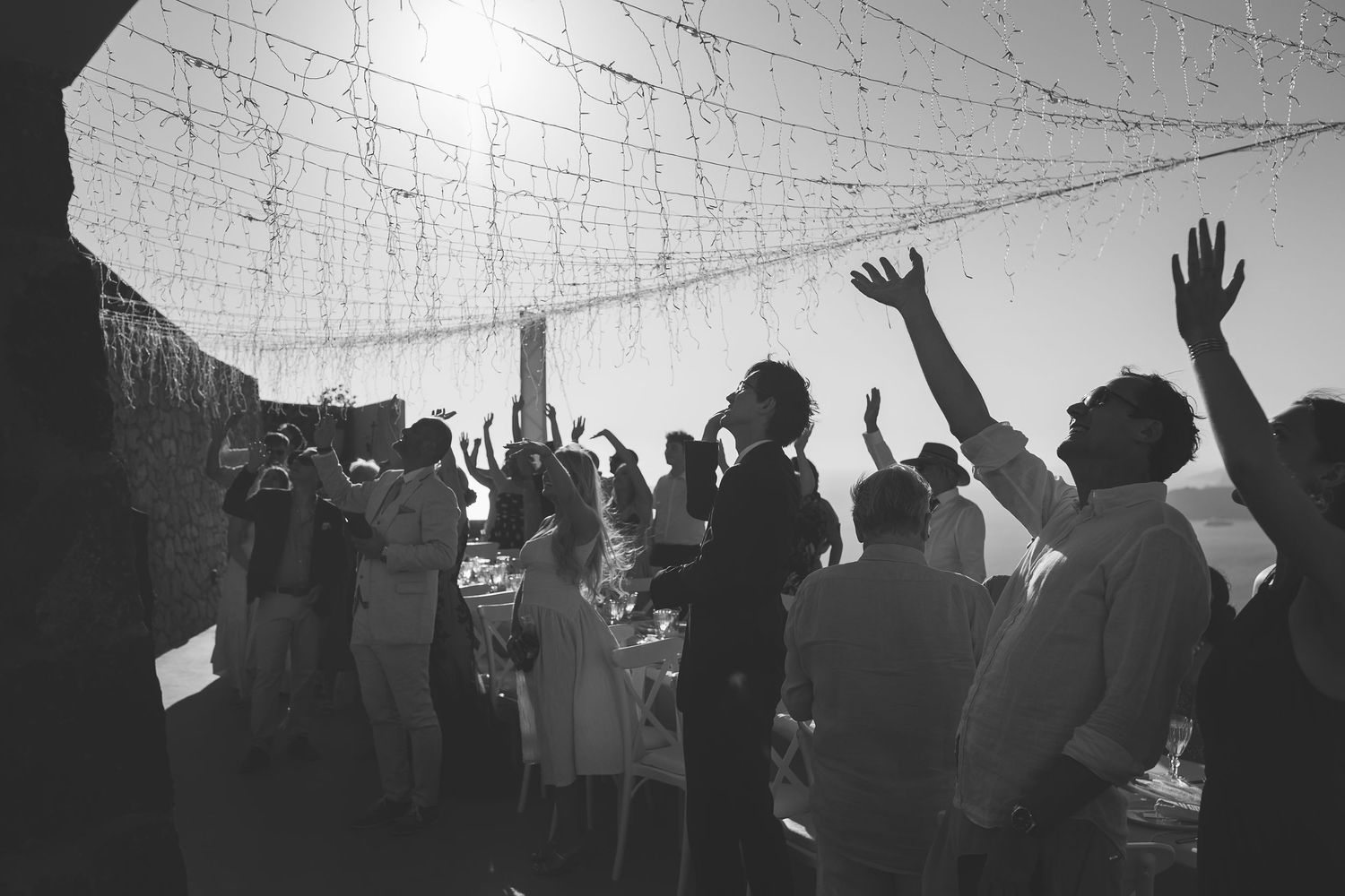 Silhouettes of Santorini wedding guests waving