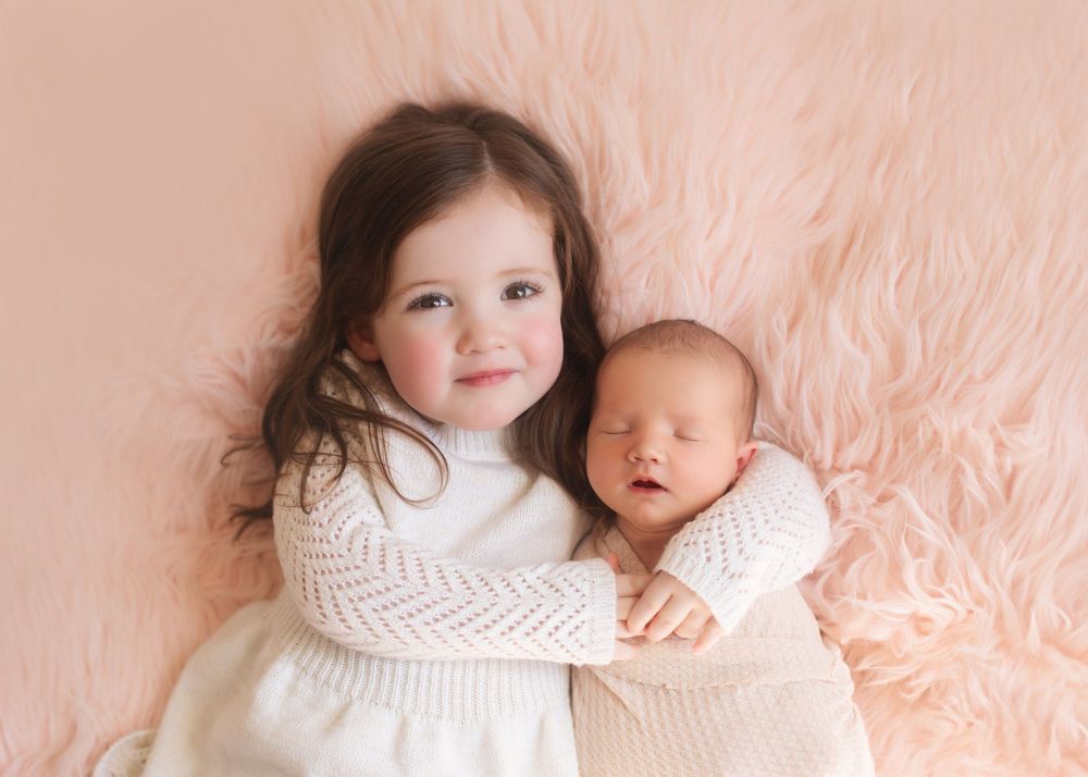 Sweet portrait series of siblings on pink background with soft lighting.