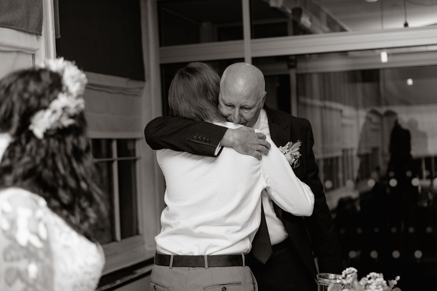 Hug between daughter and father together at a formal event in an elegant ballroom setting.