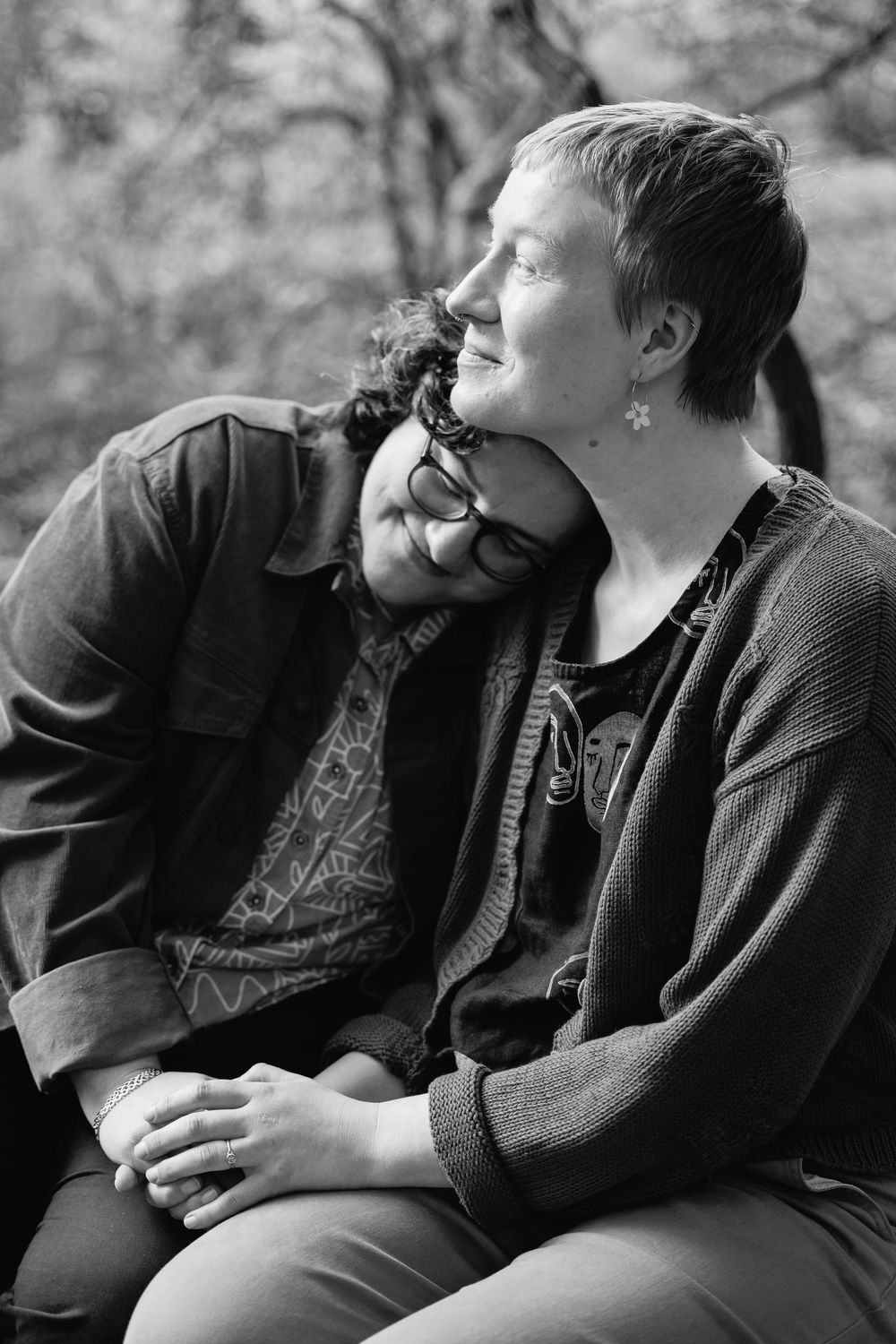 Black and white portrait of two women sitting close together, one leaning on the other's shoulder lovingly.