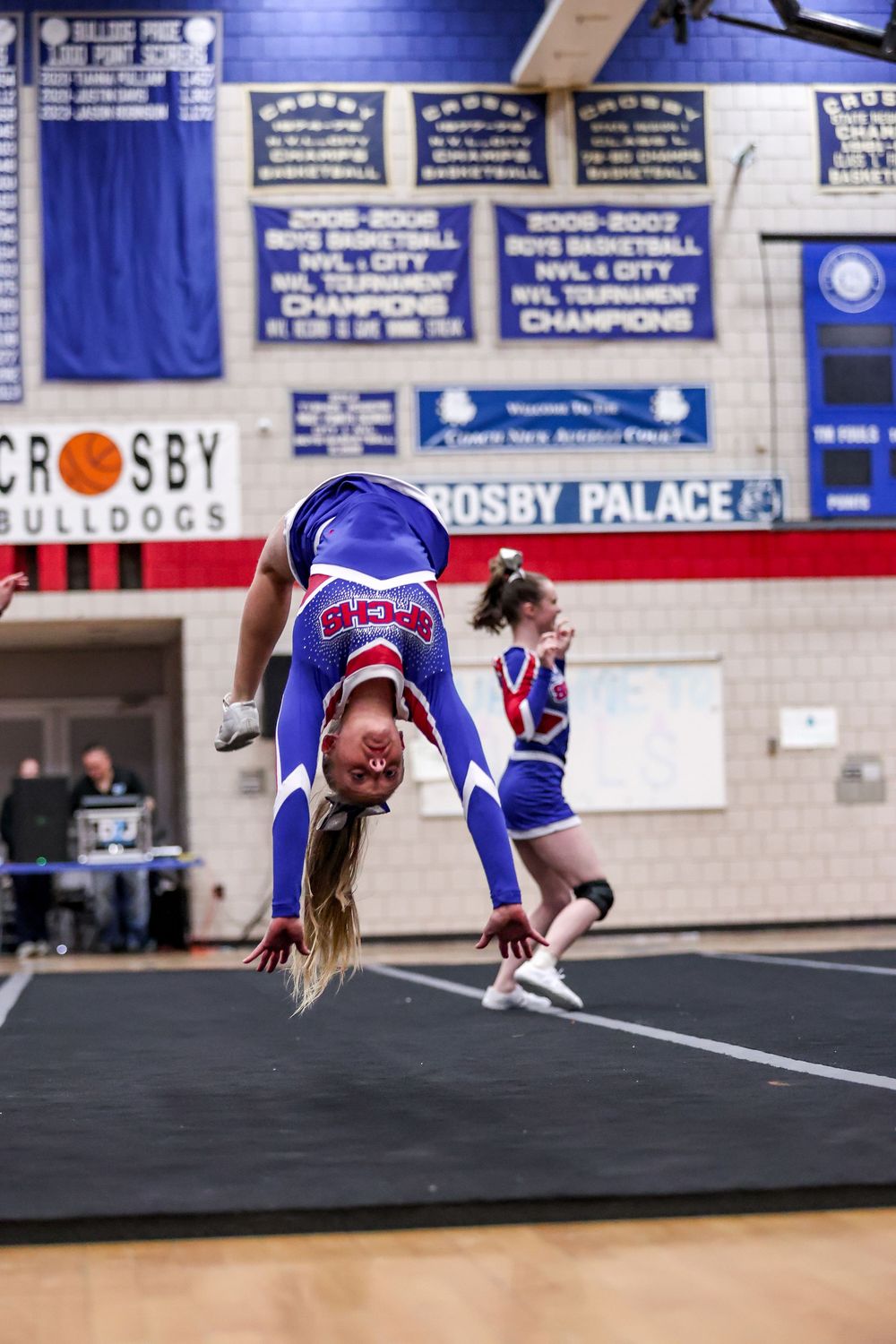 A cheerleader performs a back handspring during a competition at Crosby Palace gymnasium.