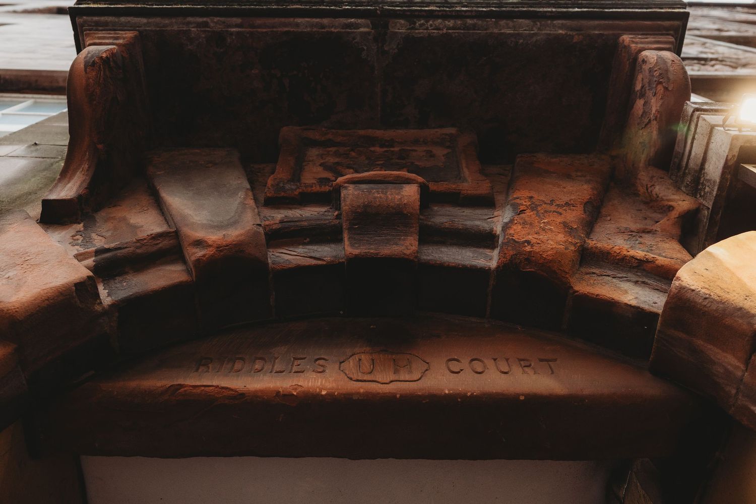 Close-up view of an old weathered stone archway with rustic brown architectural details.
