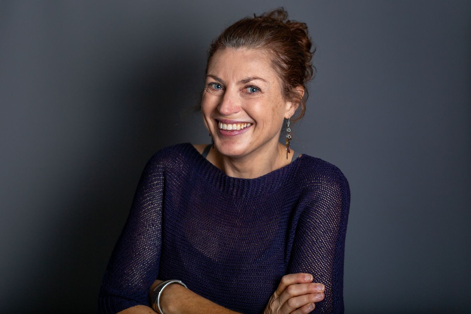 Professional headshot series showing joyful expressions and genuine laughter against a dark background.