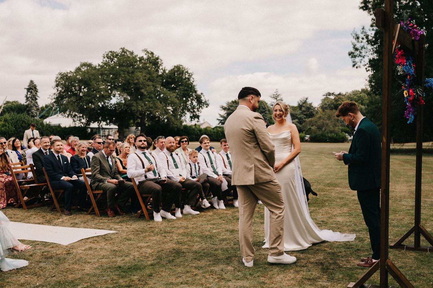 A panoramic collage of an outdoor wedding ceremony with guests seated on white chairs in a grassy field.