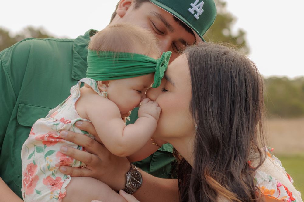 Sweet outdoor family moments captured in a series of photos with green baseball cap and floral dress.