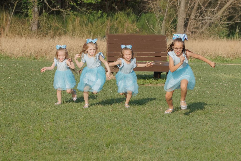 Group wearing matching blue outfits playing together on grass field.