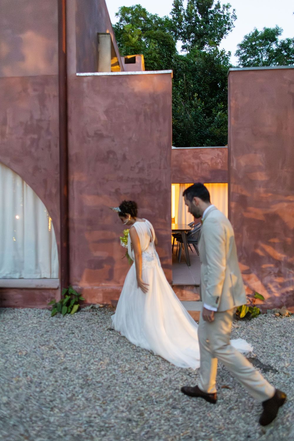 A sequence of photos showing a couple walking together at dusk along a rustic wall with warm lighting.