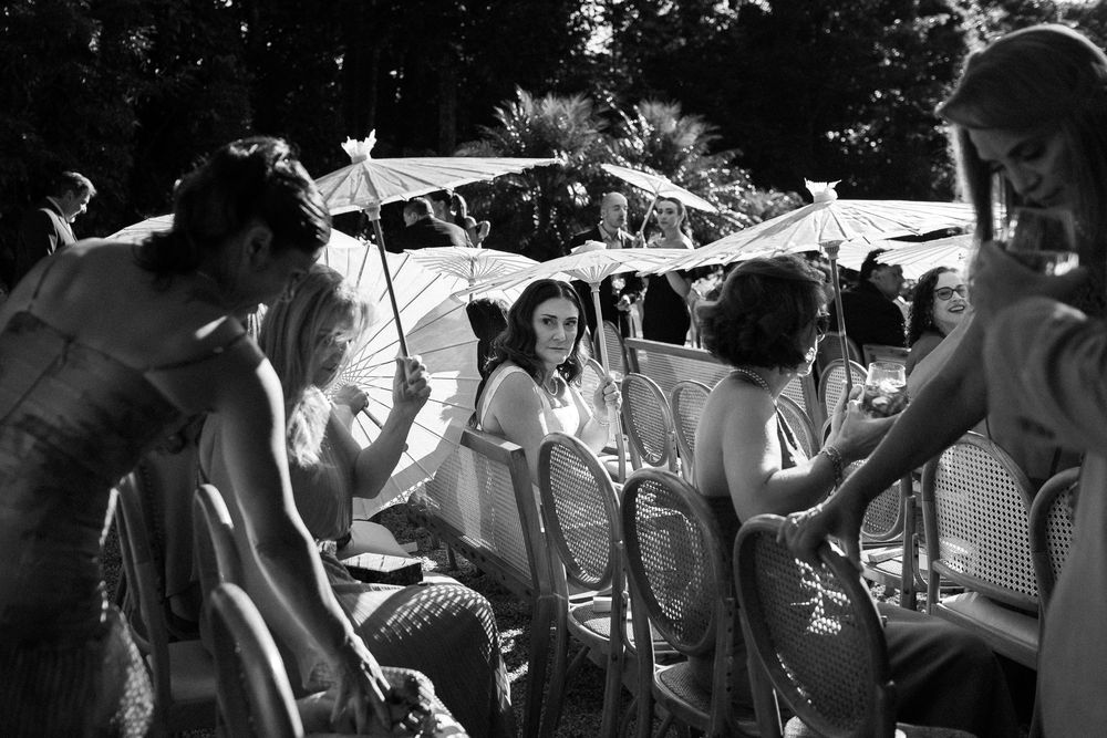 Black and white photos of wedding guests celebrating during an outdoor reception.