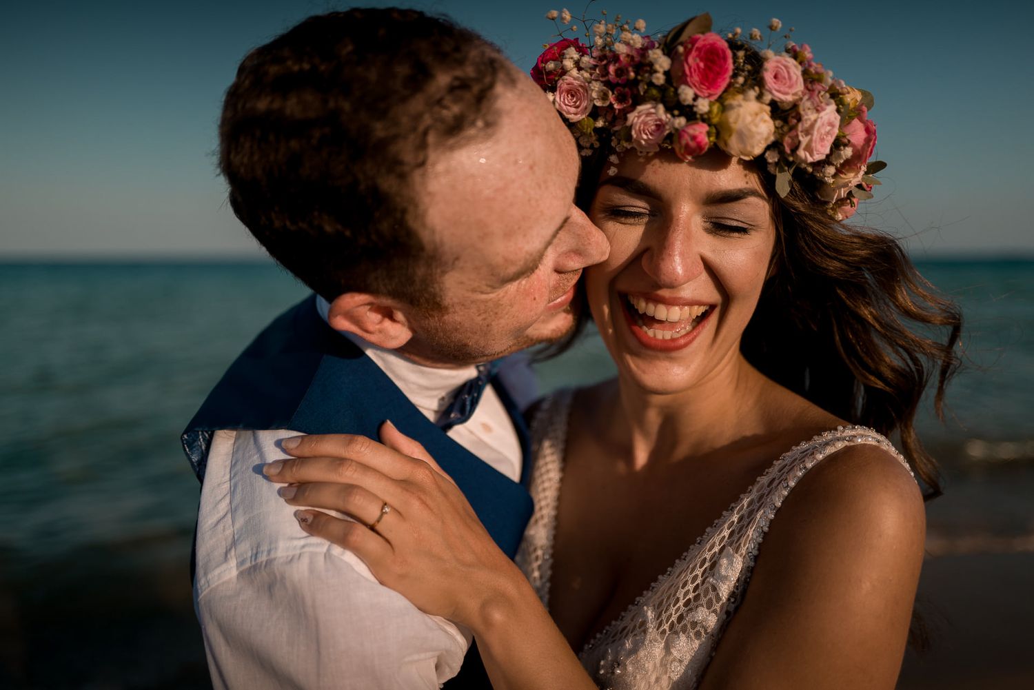 Brautpaar lacht herzlich am Strand: Ungestellte Hochzeitsfotografie, die echte Emotionen und Freude festhält